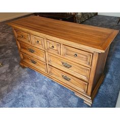 a large wooden dresser sitting on top of a blue carpet