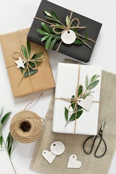 three wrapped presents tied with twine on top of each other, sitting next to some twine