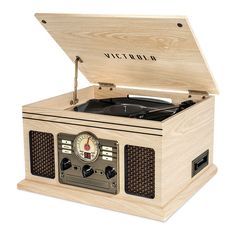 an old fashioned record player in a wooden box with the lid open and clock on top