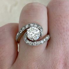 a woman's hand with a diamond ring on top of her finger and an engagement band