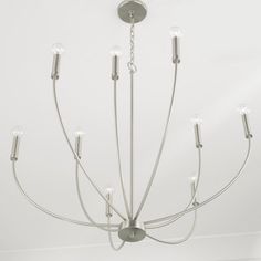 a chandelier hanging from the ceiling in a room with white walls and flooring