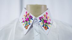 a white shirt with colorful flowers on the collar