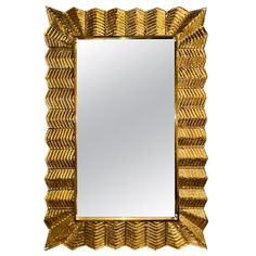 a mirror that is sitting on top of a white surface with gold leaf decoration around it