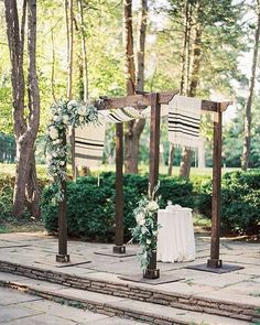 an outdoor ceremony setup with white flowers and greenery