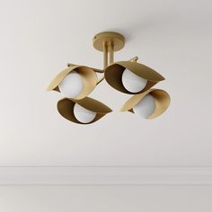 a modern light fixture hanging from the ceiling in a room with white walls and flooring