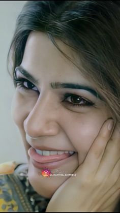 a close up of a person with a smile on their face and hand near her face