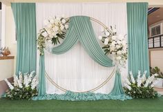 a green and white wedding backdrop with flowers