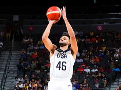 a basketball player is getting ready to dunk the ball in front of an audience