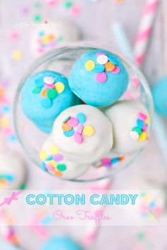 a glass filled with blue and white donuts covered in sprinkles on top of a table