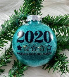 a blue ornament hanging from a christmas tree with the year 2020 written on it