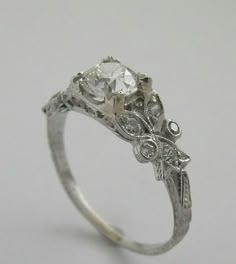 an antique style diamond engagement ring with filigrees