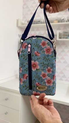 a person holding onto a blue floral purse