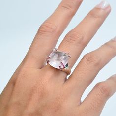 This stunning ring features a captivating cushion-cut Rose Quartz center stone, exuding a soft pink hue that symbolizes love and tranquility. The centerpiece is securely held by unique, stylish prongs adorned with vibrant Ruby gemstones, adding a touch of passionate red to the serene pink. The sleek, high-polished silver band enhances the overall elegance, making it a perfect statement piece for any occasion. This ring seamlessly blends modern design with classic charm, creating a timeless acces Formal Pink Cushion Cut Ring, Fine Jewelry Pink Cabochon Ring, Pink Formal Rings With Rose Cut Diamonds, Formal Pink Rings With Rose Cut Diamonds, Elegant Pink Cabochon Ruby Ring, Elegant Pink Ruby Cabochon Ring, Elegant Pink Cabochon Rings, Elegant Pink Moonstone Ring For Anniversary, Polish Silver