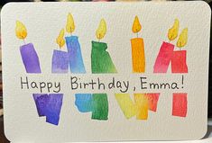 a birthday card with candles and the words happy birthday emma written in rainbow colors