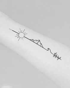 a person with a tattoo on their arm that has the sun and mountains in it