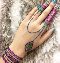 a woman's hand with bracelets and rings on it