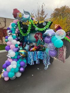 an elaborate vehicle decorated with mermaid balloons and streamers