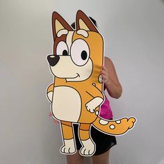 a woman holding up a cut out of a cartoon cat