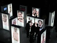 a group of people standing in front of pictures on the wall with faces projected on them