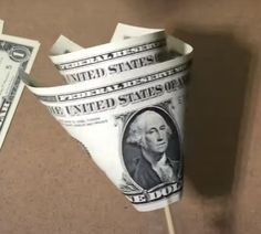 one hundred dollar bill sticking out of a cup