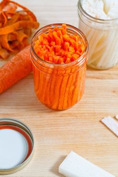 carrots and other food items on a table next to a jar of yogurt