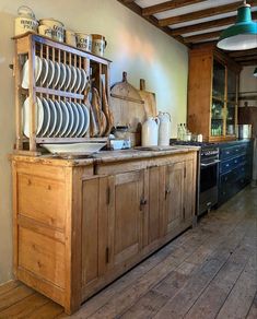 an old fashioned kitchen with lots of dishes on the counters and cupboards in it