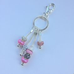 a keychain with charms attached to it on a white surface, showing the charm and bead details