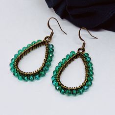 These lovely earrings are handmade using green crystal glass beads. The beads are carefully and individually wrapped around bronze teardrop pendants with bronze, tarnish-resistant wire and hang from hypoallergenic bronze earring hooks. The earrings measure approximately 2" long from the top of the earring hook to the bottom teardrop pendant. (Please see the pictures that include a measuring tape and/or quarter for size reference.)  They are perfect to give as a gift or to treat yourself to something special.  Colors may appear slightly different in images when displayed on your screen. Cotton Filled Box Included. Handmade in the USA. ------  Find more Beautiful Pieces at AshbeesAccessories 🛍 Shop: https://www.etsy.com/shop/AshbeesAccessories Necklaces: https://www.etsy.com/shop/AshbeesAcc Cheap Green Beaded Teardrop Earrings, Handmade Green Crystal Metal Earrings, Green Teardrop Beaded Earrings With Wire Wrap, Green Teardrop Beaded Earrings With Wire Wrapped Detail, Green Wire Wrapped Teardrop Beaded Earrings, Green Teardrop Wire Wrapped Beaded Earrings, Teardrop Green Crystal Earrings, Green Teardrop Earrings With Faceted Beads, Green Teardrop Crystal Earrings Handmade