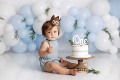 a baby sitting in front of a cake