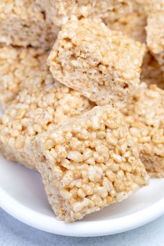 rice krispy treats stacked on top of each other in a white bowl, ready to be eaten