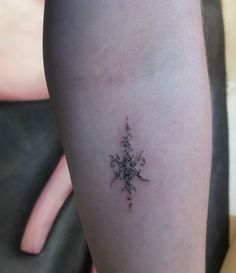 a small tattoo on the leg of a woman's left arm, with an intricate design