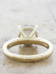 a yellow gold engagement ring with a single diamond in the center and two smaller diamonds on each side