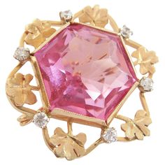 Retro 14K yellow gold custom made brooch - set with one hexagonal cut pink crystal (approx. 24 carats - 20 mm. x 17 mm. x 13 mm. deep) - surrounded by gold chased sprigs of clover and six claw set clear crystals (approx. 1/3 carat total - 2 mm. diameter each) - beautifully finished back with twisted rope detail - original pin with custom spring hinge and 'c' catch - signed 'A.M.' (unidentified maker) - acid tested for gold purity - Italy (likely) - circa 1960's. Excellent vintage condition - couple of chips to the pink crystal (likely an older crystal reset in this brooch) - no loss - no damage - no repairs - signs of age and use - ready to wear. Size/Dimensions - Medium - 1 1/4" (3.2 cm.) Diameter x 5/8" (1.6 cm.) Deep (Including Pin). Weight - 13.65 Grams (Total). Pink Sapphire Brooch, Antique Pink Brooch Jewelry, Crystal Brooch Pink, Vintage Pink Collectible Brooches, Vintage Gold Multi-stone Brooches, Crystal Brooch, 3 Carat, Pink Crystal, Aging Signs