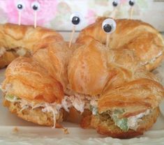 some croissants with googly eyes and toothpicks in the middle