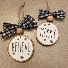 two wooden ornaments with black and white bows on them