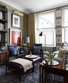 a living room filled with furniture and a large window next to a bookshelf