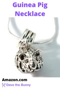 an animal charm with the words guinea pig necklace on it's front and back side