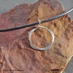 "This necklace is a modern version of the popular open circle necklace. Each sterling silver argentium pendant has been hammered and tumbled to a high shine. The open circle pendant measures approx 1\" wide by 1.375\" high including the connection to the leather cord. This pendant is formed from thicker gauge wire and is very lightweight. You may choose either black or brown 3mm leather cord. If you would like another color cord, please send me a convo. The lobster clasp on this necklace is made Modern Hammered Sterling Silver Necklace, Modern Hammered Round Necklace, Modern Hammered Open Circle Jewelry, Modern Hammered Necklace With Round Pendant, Modern Hammered Round Pendant Necklace, Leather Necklace Women, Big Pendant Necklace, Bronze Anniversary Gifts, Hammered Pendant