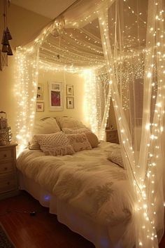 a white bed with lights on the headboard and canopy over it's bedspread