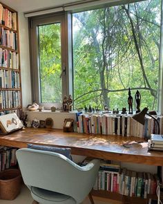 a chair sitting in front of a window filled with books