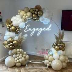 balloon arch with gold and white balloons in the shape of an arch, decorated with palm leaves