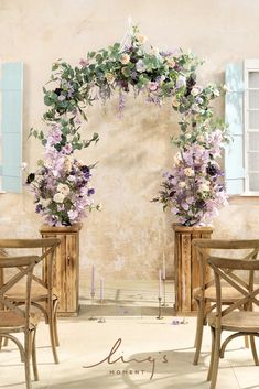 two wooden chairs sitting next to each other in front of a table with flowers on it