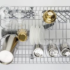 there are many silver and gold dishes on the rack