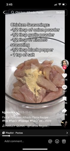 a glass bowl filled with chicken and seasoning on top of a white countertop