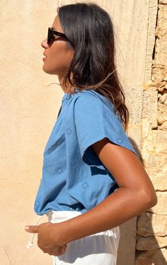 Our Signature shirt in a gorgeous chambray with tone on tone blue woven details with metallic dot . Easy to wear from beach to city. We promise this top will be your go-to warm weather item. Perfect under a blazer. Opaque weight and truly a special fabric. This Handwoven Fabric is custom designed by Two. Color: Medium Indigo Summer Workwear Shirt, Light Indigo Relaxed Fit Cotton Blouse, Light Indigo Cotton Blouse With Relaxed Fit, Summer Workwear Blouse In Indigo, Chic Cotton Light Indigo Top, Indigo Cotton Tops For Day Out, Chic Light Indigo Cotton Tops, Light Blue Linen Summer Blouse, Indigo Linen Summer Tops