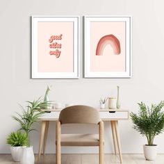 two framed art prints on the wall above a desk with a chair and potted plant