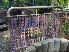 there are many blue and red circles on the metal fence in front of some trees