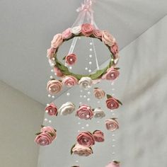 a pink and white flowered mobile hanging from the ceiling