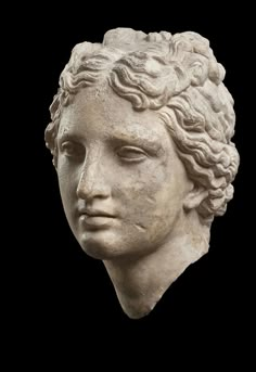 a white marble head with curly hair on a black background