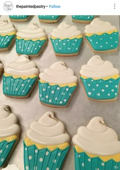 blue and white decorated cupcakes sitting on top of a table